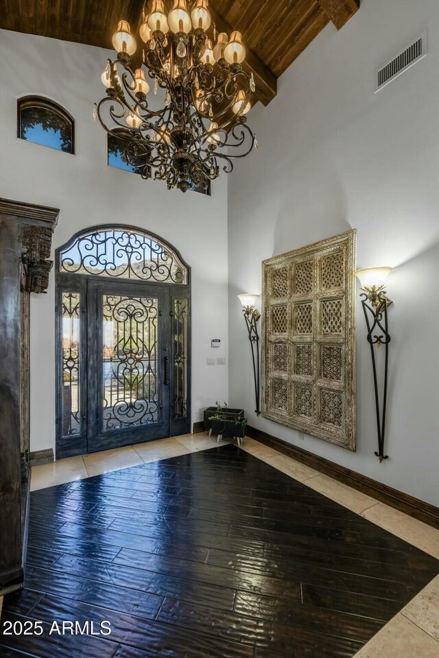 foyer with hardwood / wood-style flooring, beam ceiling, wooden ceiling, and a high ceiling