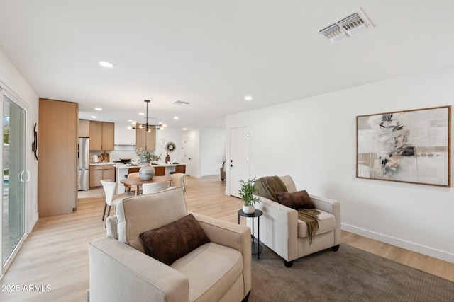 living room featuring an inviting chandelier and light hardwood / wood-style floors