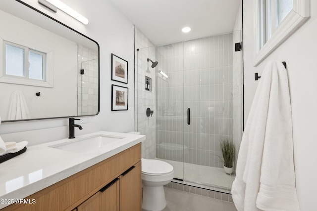 bathroom with walk in shower, vanity, and toilet