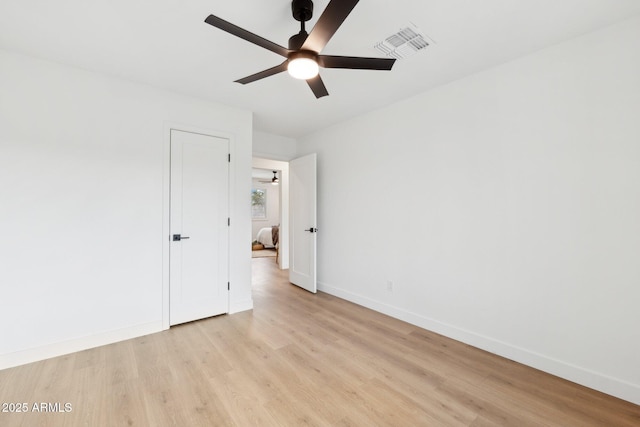 spare room with ceiling fan and light wood-type flooring