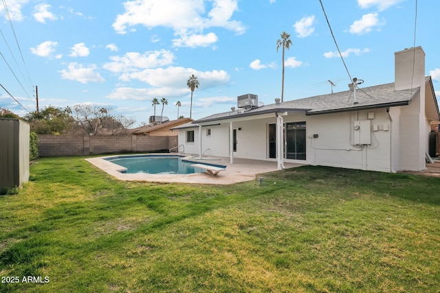 rear view of house with a fenced in pool, a patio, a yard, and central air condition unit