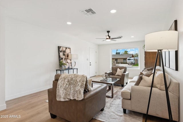 living room featuring ceiling fan and light hardwood / wood-style flooring