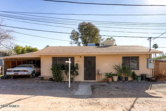 view of front of property with an attached carport, driveway, and stucco siding