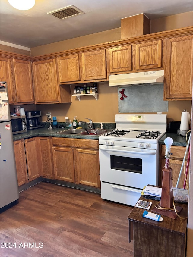 kitchen with visible vents, under cabinet range hood, dark wood-style floors, stainless steel appliances, and a sink