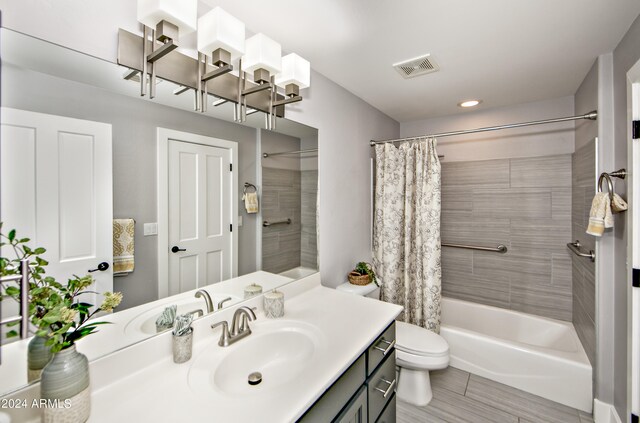 full bathroom featuring shower / tub combo, tile patterned floors, toilet, and vanity