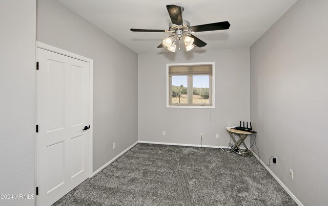 carpeted spare room featuring ceiling fan