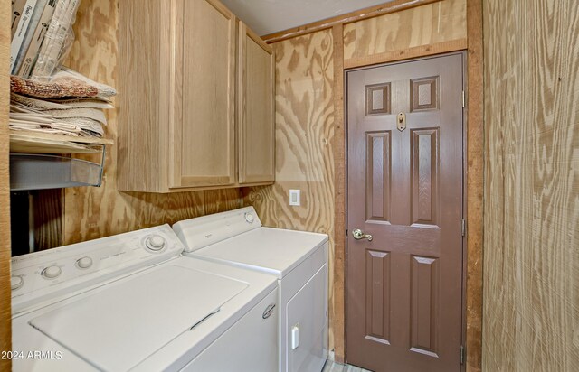 washroom with washer and dryer and cabinets