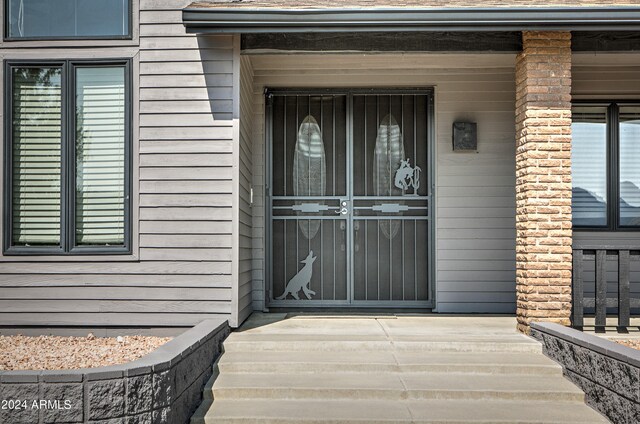 view of exterior entry featuring covered porch