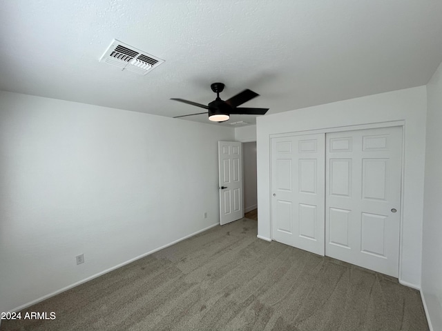 unfurnished bedroom with ceiling fan, a closet, and carpet