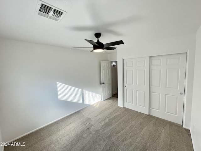 unfurnished bedroom featuring ceiling fan, light colored carpet, and a closet