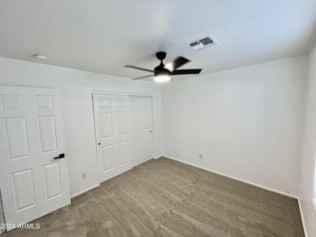 unfurnished bedroom with carpet flooring, ceiling fan, and a closet