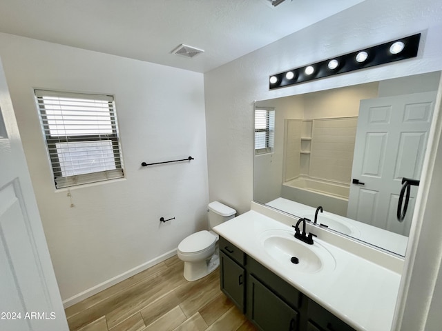 full bathroom with hardwood / wood-style floors, vanity, toilet, and tub / shower combination