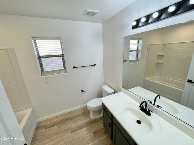 full bathroom with hardwood / wood-style floors, vanity,  shower combination, and toilet