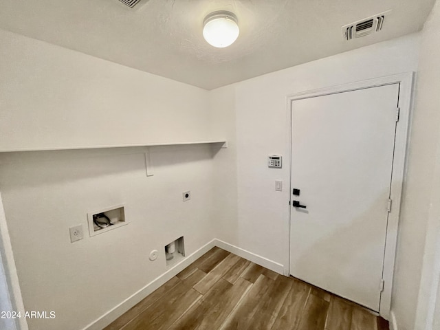 washroom featuring hardwood / wood-style flooring, electric dryer hookup, hookup for a gas dryer, and washer hookup