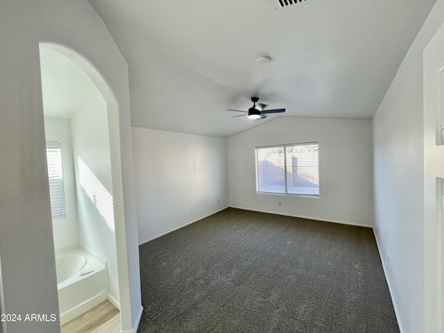 unfurnished room with dark colored carpet, ceiling fan, and lofted ceiling