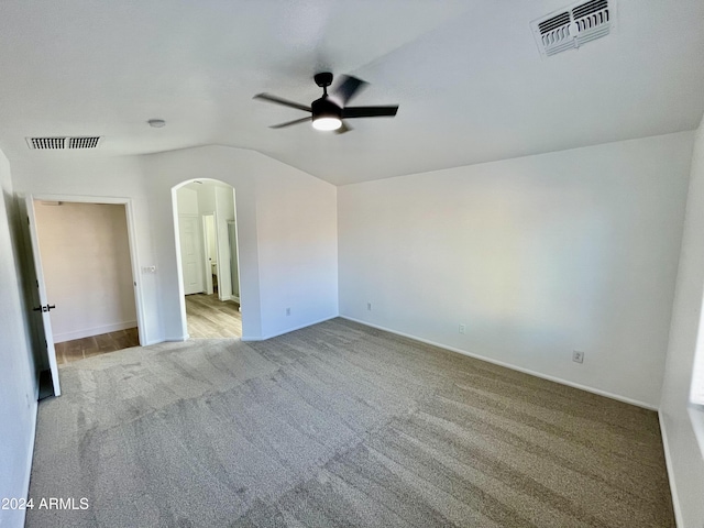 empty room featuring light carpet, ceiling fan, and lofted ceiling