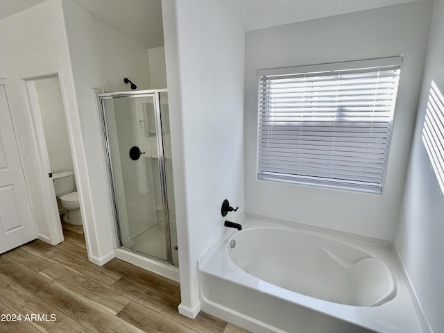 bathroom featuring plus walk in shower, wood-type flooring, and toilet