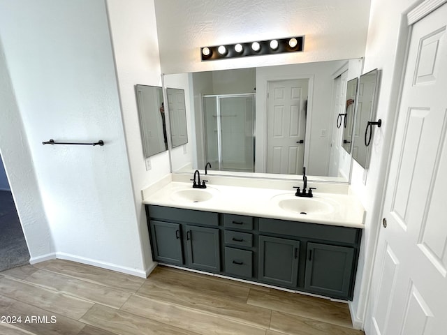 bathroom featuring hardwood / wood-style floors, vanity, and an enclosed shower