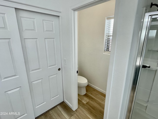 bathroom with hardwood / wood-style floors and toilet