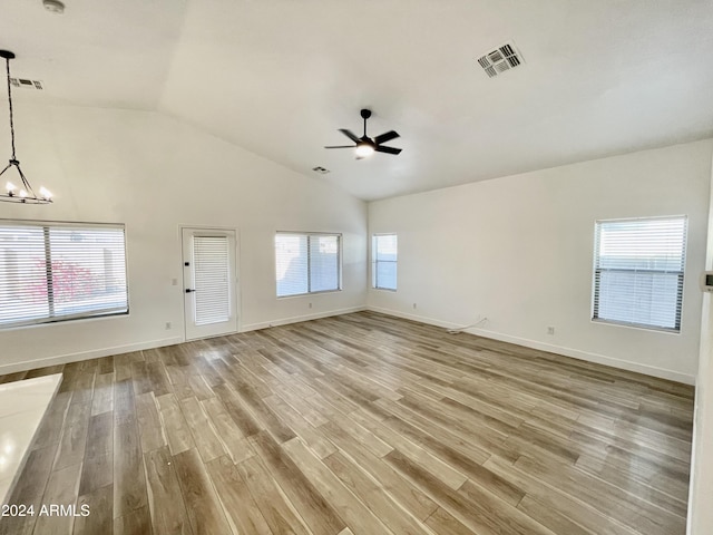 unfurnished living room with a wealth of natural light, light hardwood / wood-style floors, and vaulted ceiling