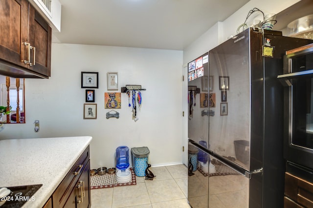 kitchen with black electric cooktop, fridge, dark brown cabinets, and light tile patterned flooring