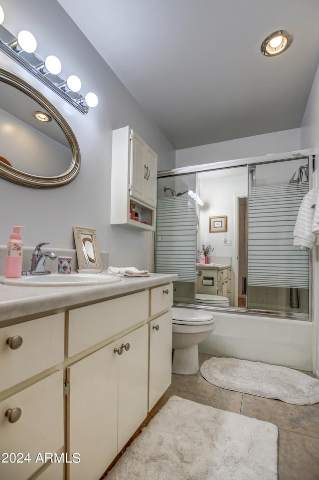 full bathroom with tile patterned flooring, toilet, combined bath / shower with glass door, and vanity