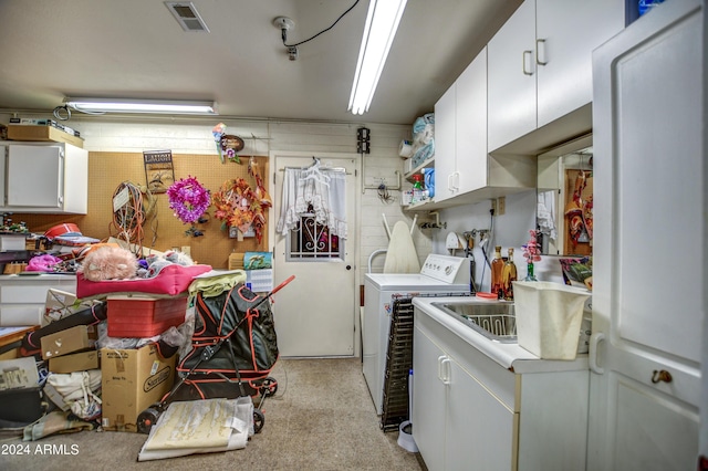 washroom featuring independent washer and dryer, cabinet space, and visible vents