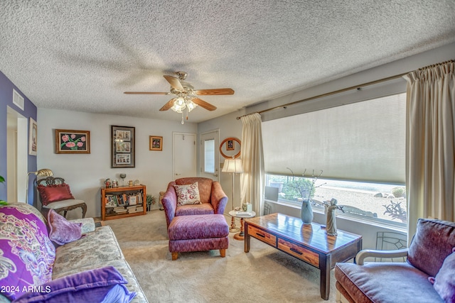 living room with a textured ceiling, carpet flooring, and ceiling fan