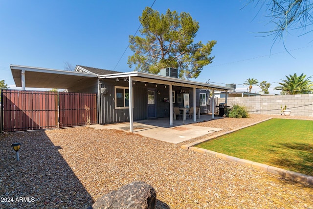 rear view of house featuring a lawn, a patio area, and central air condition unit