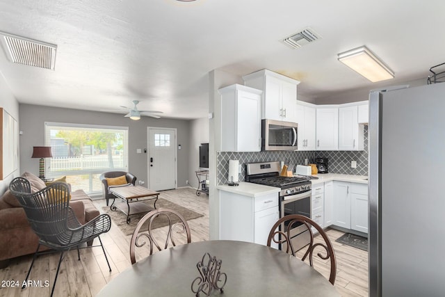 kitchen with white cabinetry, ceiling fan, light hardwood / wood-style flooring, backsplash, and appliances with stainless steel finishes