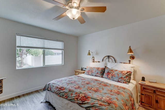 bedroom featuring light wood-style floors, baseboards, and ceiling fan