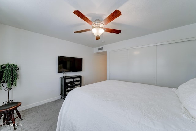 bedroom with visible vents, light carpet, a ceiling fan, a closet, and baseboards