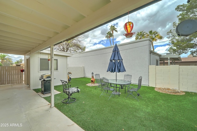 view of yard featuring a patio area, an outdoor structure, and a fenced backyard