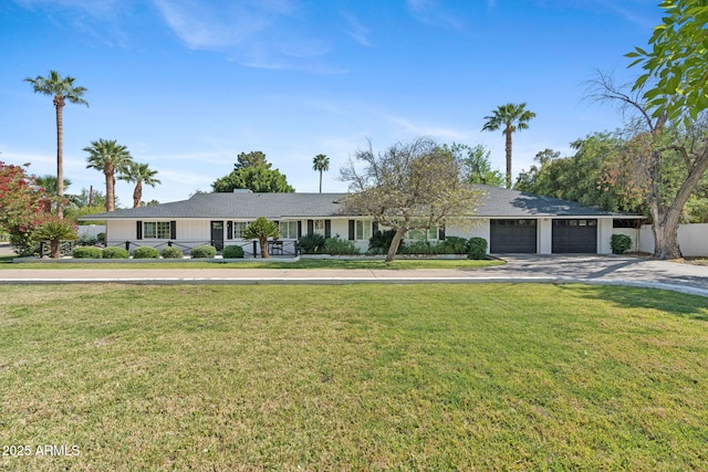 single story home with an attached garage, concrete driveway, and a front yard