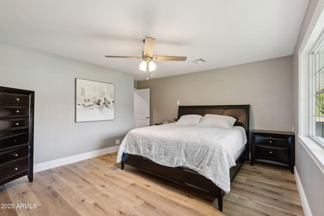 bedroom featuring ceiling fan, baseboards, visible vents, and wood finished floors