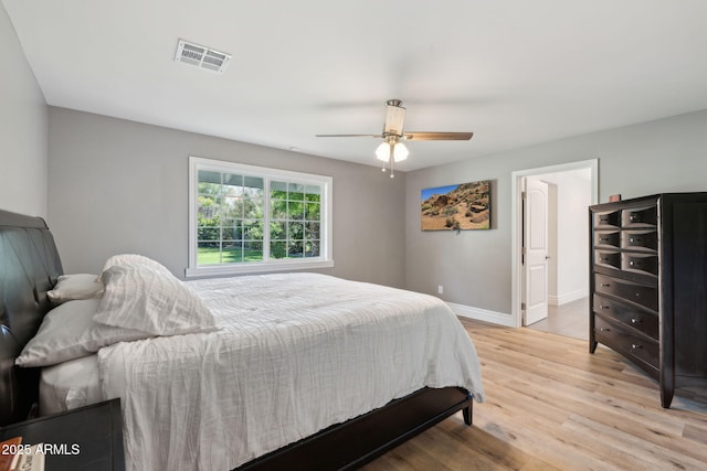 bedroom with a ceiling fan, baseboards, visible vents, and light wood-style flooring