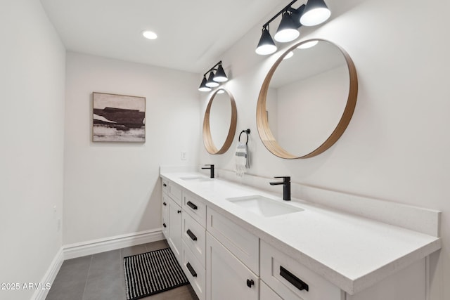 bathroom with a sink, tile patterned floors, baseboards, and double vanity