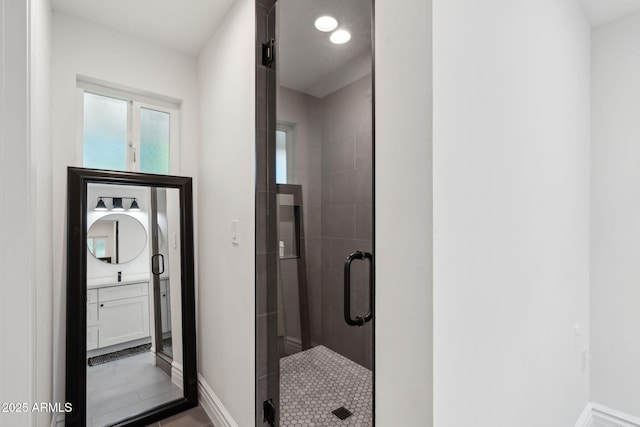 bathroom with recessed lighting, baseboards, a shower stall, and vanity