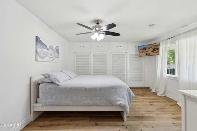bedroom with baseboards, ceiling fan, and light wood-style flooring