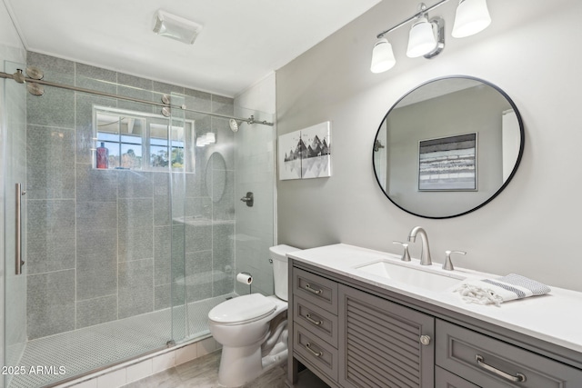 bathroom featuring toilet, visible vents, a shower stall, and vanity