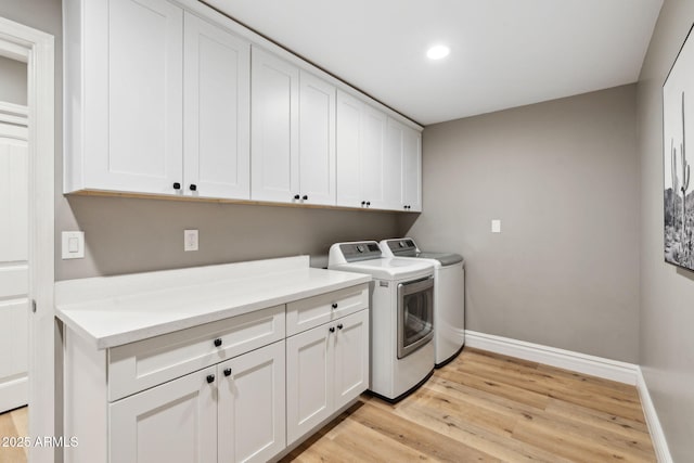 laundry area featuring washing machine and dryer, cabinet space, baseboards, light wood finished floors, and recessed lighting