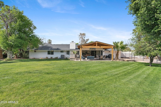 back of house with fence, a patio, a chimney, and a yard