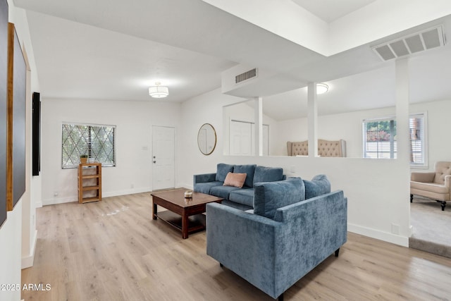 living area with visible vents, a healthy amount of sunlight, and light wood-type flooring