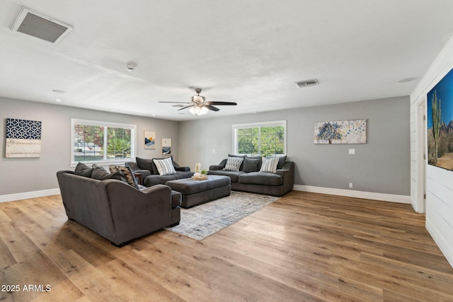living area featuring visible vents, a wealth of natural light, and wood finished floors