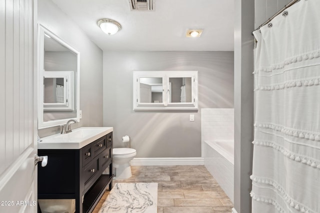 full bathroom with tiled tub, visible vents, wood finished floors, vanity, and toilet