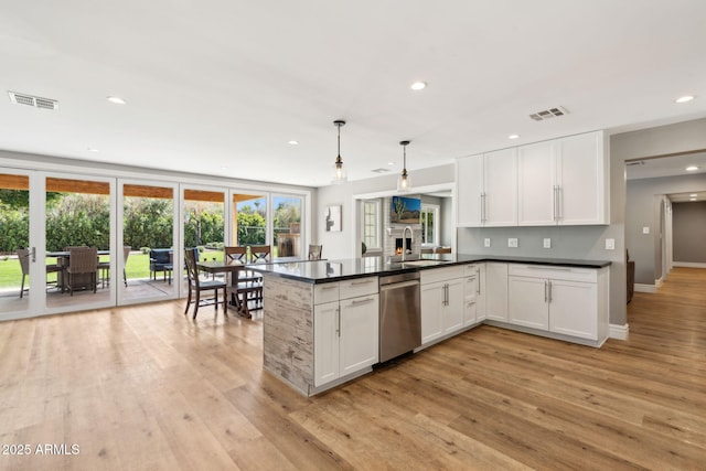 kitchen with a sink, visible vents, light wood-style floors, and dishwasher