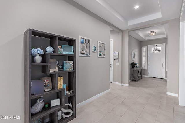 tiled foyer entrance featuring a tray ceiling