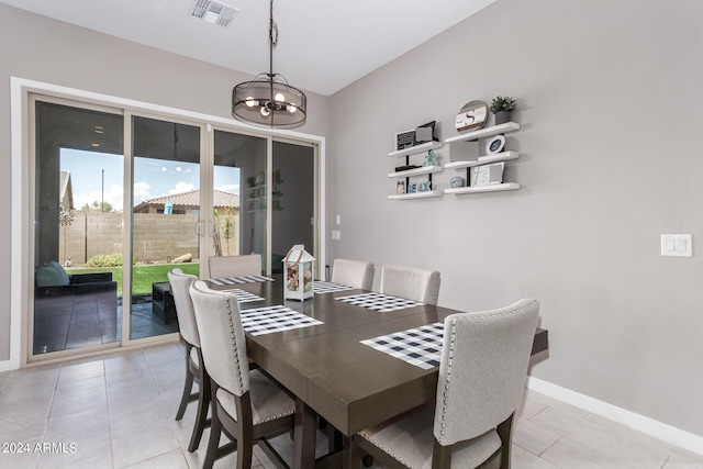 dining space with light tile patterned flooring and an inviting chandelier