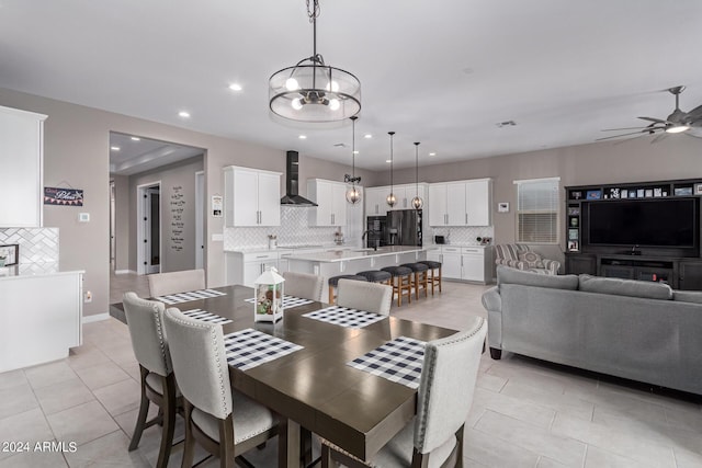 dining room featuring ceiling fan with notable chandelier, light tile patterned floors, and sink