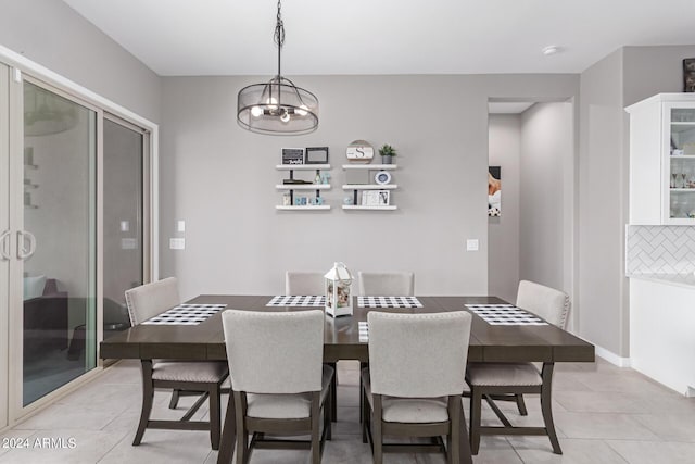 dining area with a chandelier and light tile patterned floors